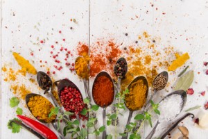 Various colorful spices on wooden table, top view.