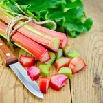 Rhubarb cut with a knife on a wooden board
