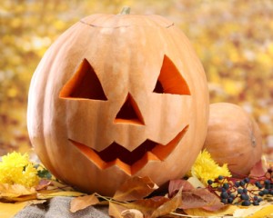 halloween pumpkins and autumn leaves, on yellow background