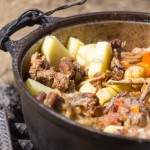 meat with potatoes in a cauldron on fire