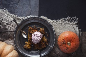 Pumpkin dump cake with ice cream on the metal plate on the stone table  vertical