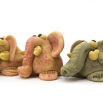 Three coloured marzipan elephants on white