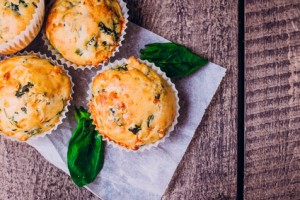 Top View of Muffins with Spinach and Cheese on Wooden Table Background. Healthy Breakfast Food Concept. Copy Space