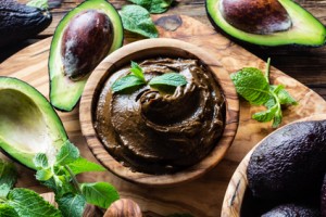 Avocado chocolate mousse on olive wooden board. Top view